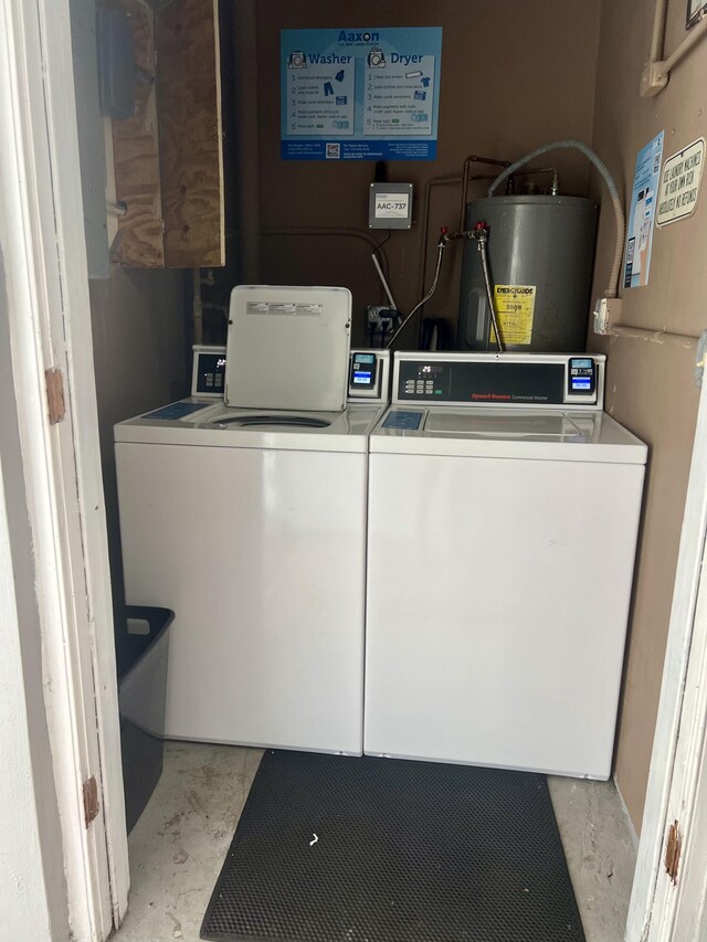 clothes washing area with gas water heater and washer and clothes dryer