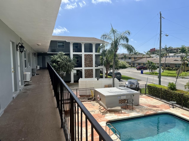 view of pool with a patio and central air condition unit