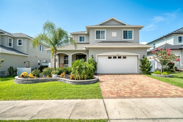 view of property with a garage and a front yard