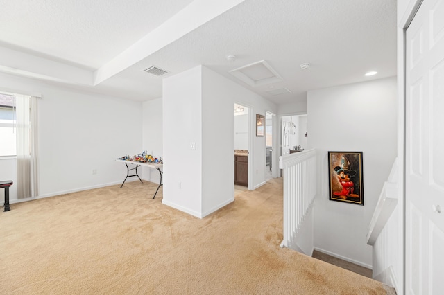 basement featuring light carpet and a textured ceiling