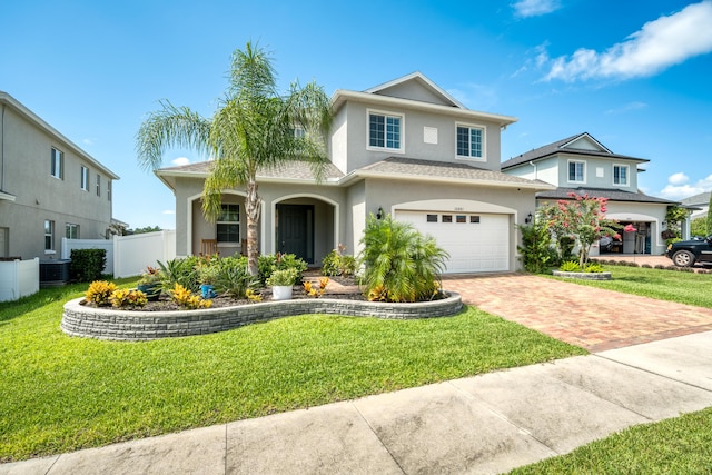 front of property with a garage, central air condition unit, and a front lawn