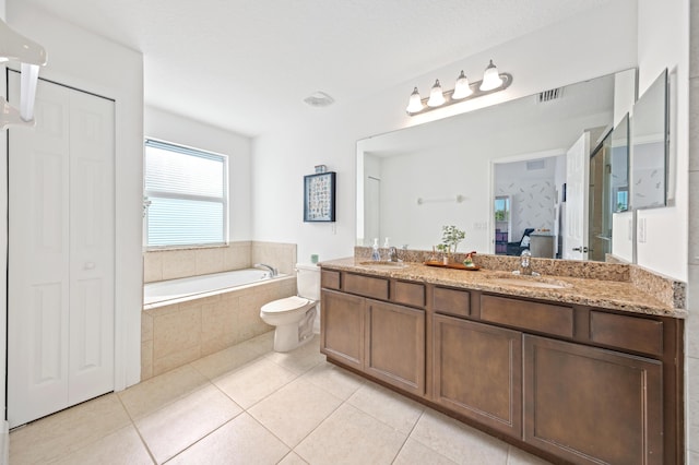 bathroom with vanity, a relaxing tiled tub, tile patterned floors, and toilet