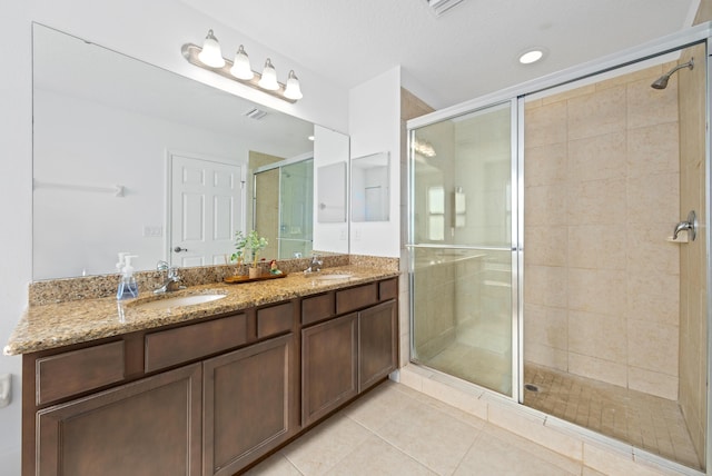 bathroom featuring vanity, a shower with shower door, and tile patterned floors