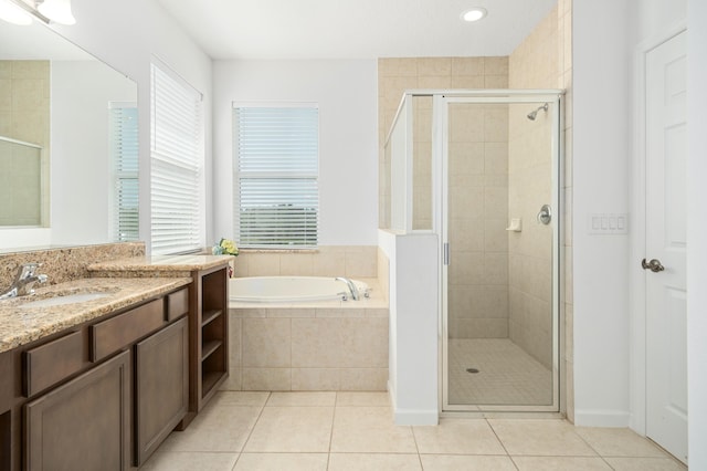 bathroom featuring tile patterned flooring, shower with separate bathtub, and vanity