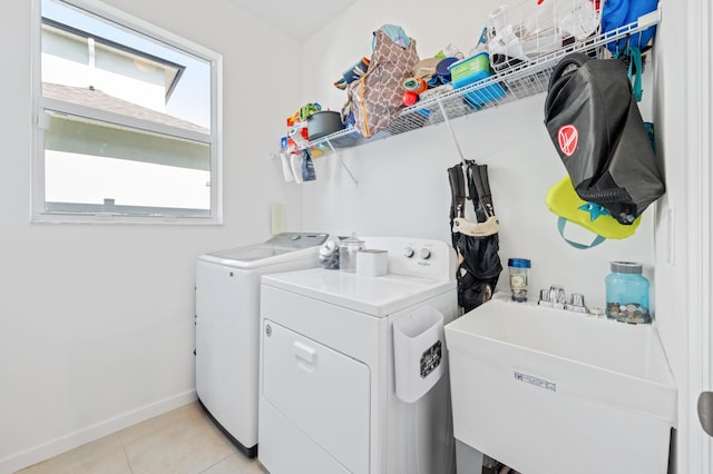 washroom with independent washer and dryer, sink, and light tile patterned floors