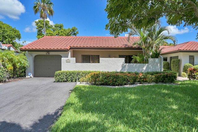 mediterranean / spanish-style home featuring a garage and a front lawn