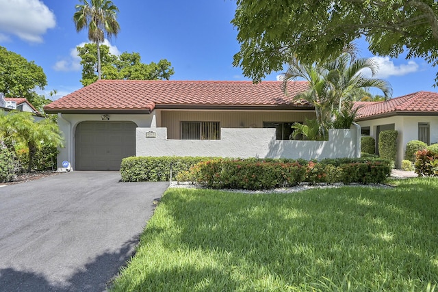 mediterranean / spanish home featuring a garage and a front yard