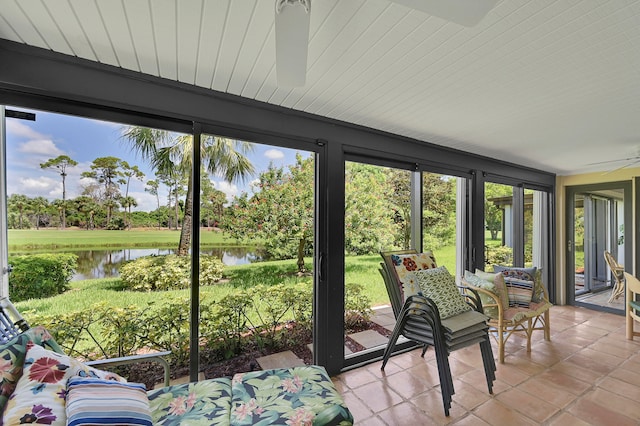 unfurnished sunroom with a water view and ceiling fan