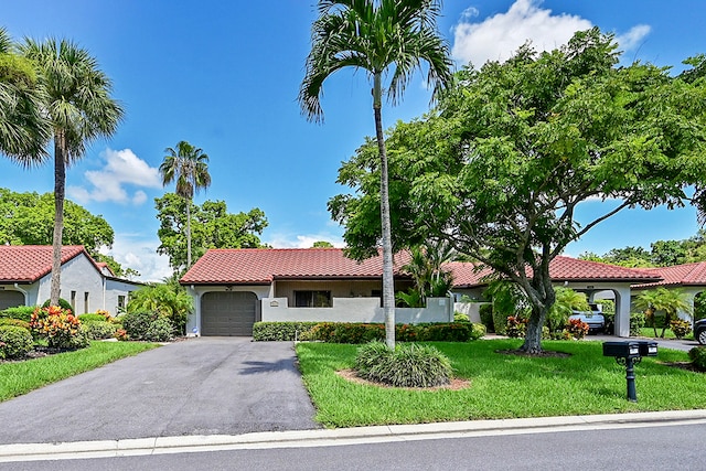 mediterranean / spanish home featuring a garage and a front yard