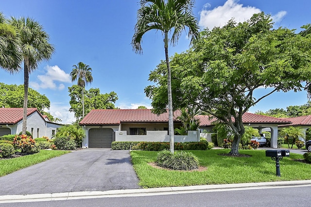 mediterranean / spanish-style home with a garage and a front lawn