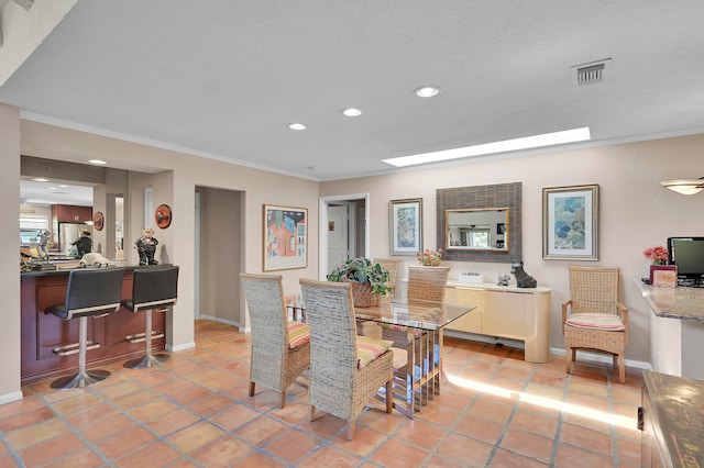 dining space with light tile patterned flooring and ornamental molding