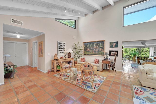 tiled living room with high vaulted ceiling, ceiling fan, track lighting, and beam ceiling