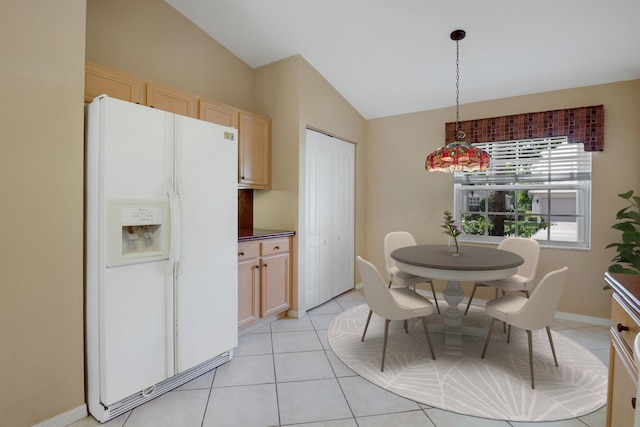 dining space with light tile patterned floors and lofted ceiling