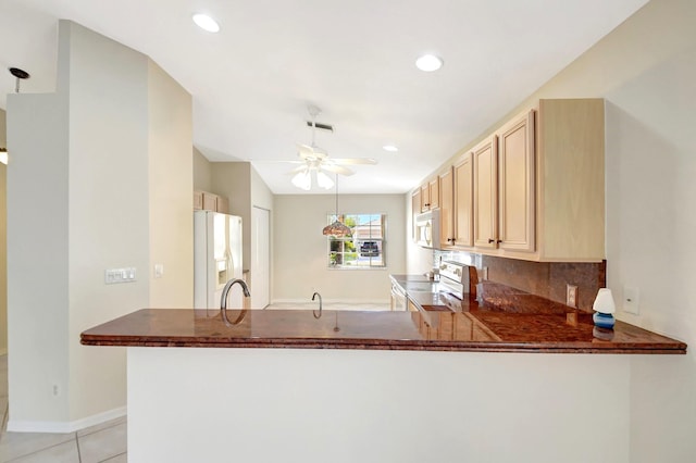 kitchen with white appliances, light tile patterned floors, kitchen peninsula, ceiling fan, and decorative backsplash