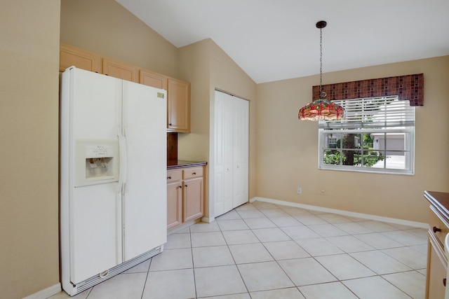 kitchen featuring lofted ceiling, white fridge with ice dispenser, and light brown cabinetry