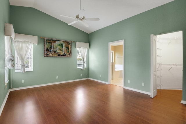 unfurnished bedroom featuring hardwood / wood-style flooring, vaulted ceiling, multiple windows, and ceiling fan