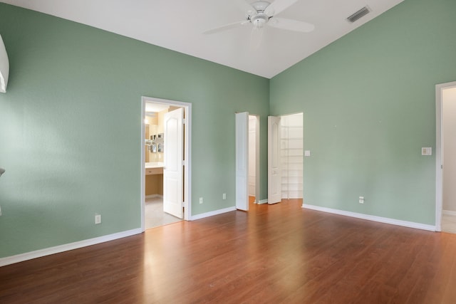 unfurnished bedroom with hardwood / wood-style floors, ceiling fan, connected bathroom, and vaulted ceiling