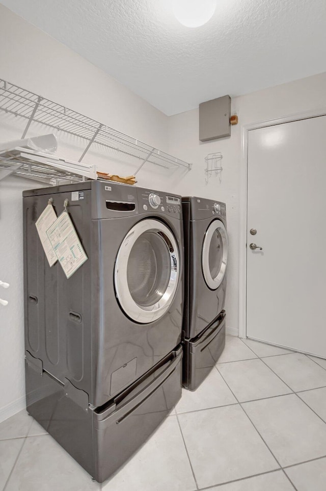 8278 Duomo Cir, Boynton Beach, FL 33472 - washroom with washer and dryer, light tile patterned flooring, a textured ceiling, and baseboards