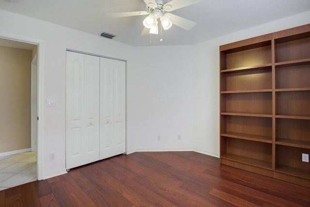 unfurnished bedroom featuring a closet, ceiling fan, and dark hardwood / wood-style flooring