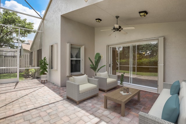 view of patio / terrace featuring an outdoor living space, glass enclosure, and ceiling fan