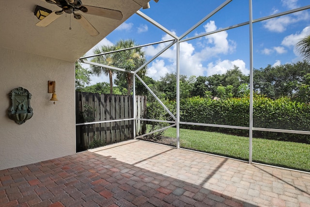 unfurnished sunroom featuring ceiling fan