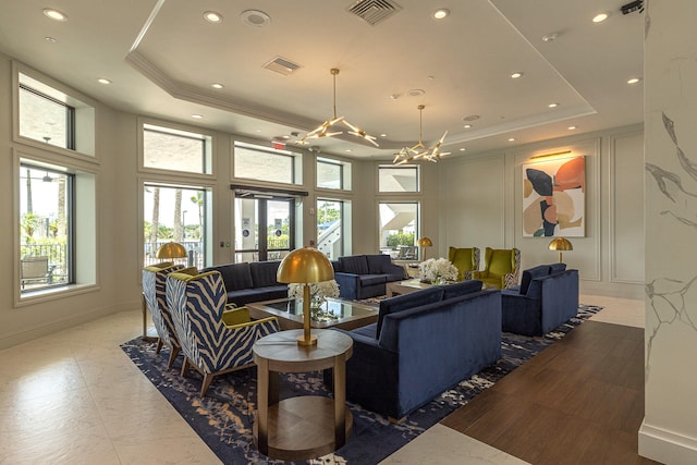 living room featuring a raised ceiling and a notable chandelier