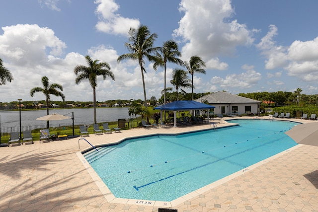 view of pool featuring a water view and a patio