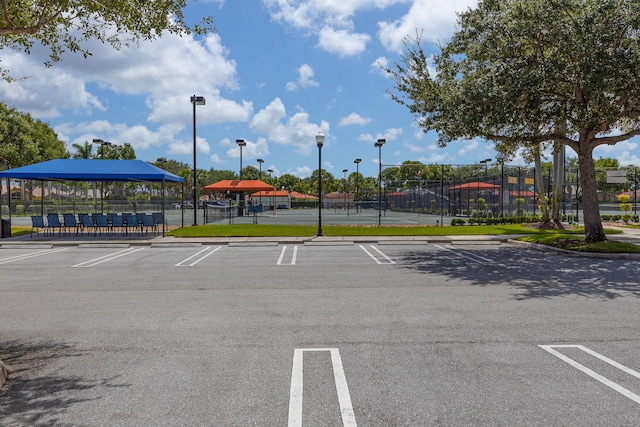 view of car parking with tennis court