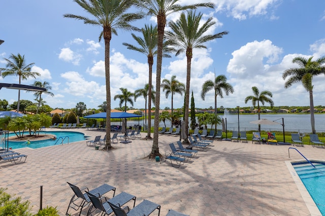 view of pool with a water view and a patio area