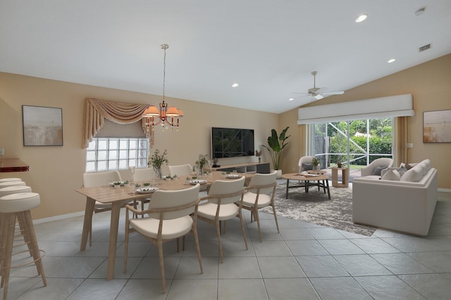 dining space with light tile patterned floors, a healthy amount of sunlight, and vaulted ceiling