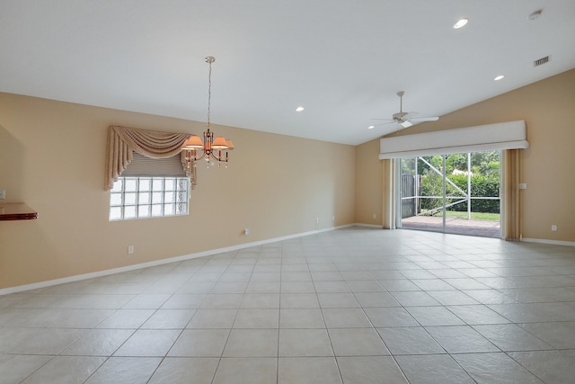 tiled spare room with ceiling fan with notable chandelier, vaulted ceiling, and a wealth of natural light