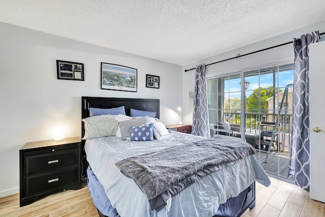 bedroom with a textured ceiling, light hardwood / wood-style flooring, and access to outside