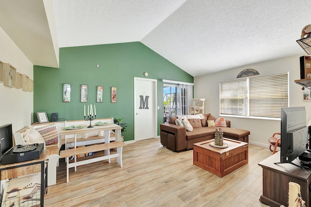 living room featuring lofted ceiling, a textured ceiling, and light hardwood / wood-style floors