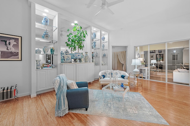 living room featuring light hardwood / wood-style flooring and ceiling fan