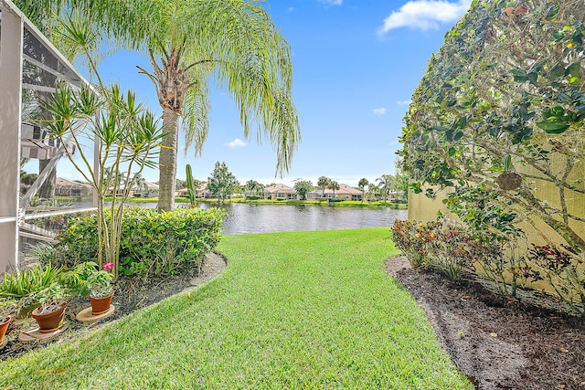 view of yard featuring a water view and glass enclosure