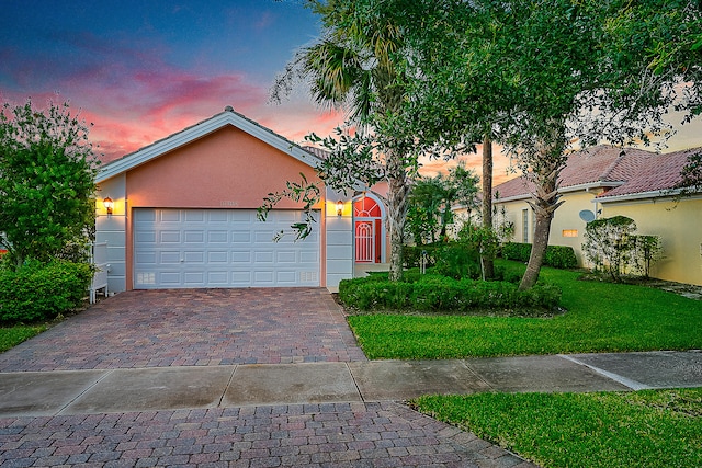 view of front facade with a yard and a garage