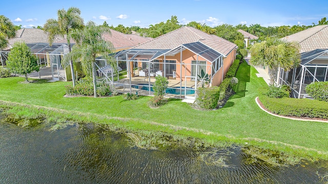 rear view of property featuring a patio, a lanai, a lawn, and a water view