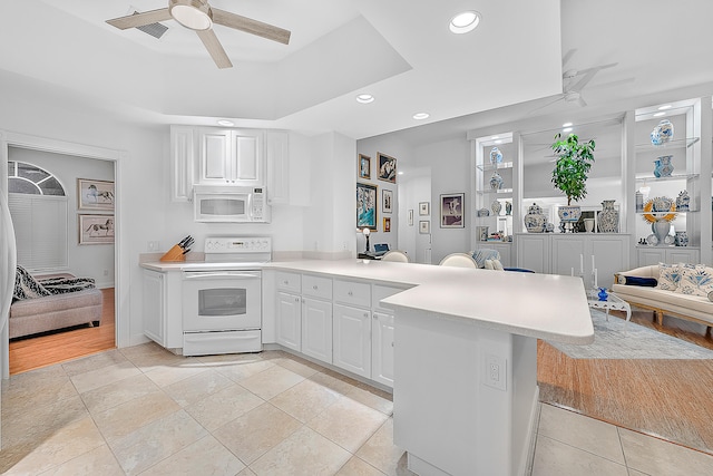 kitchen featuring white appliances, light wood-type flooring, white cabinetry, and kitchen peninsula