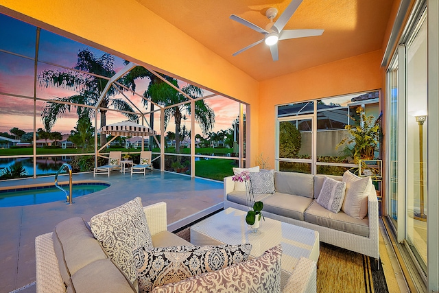 pool at dusk featuring a patio area, a lanai, ceiling fan, a water view, and an outdoor living space