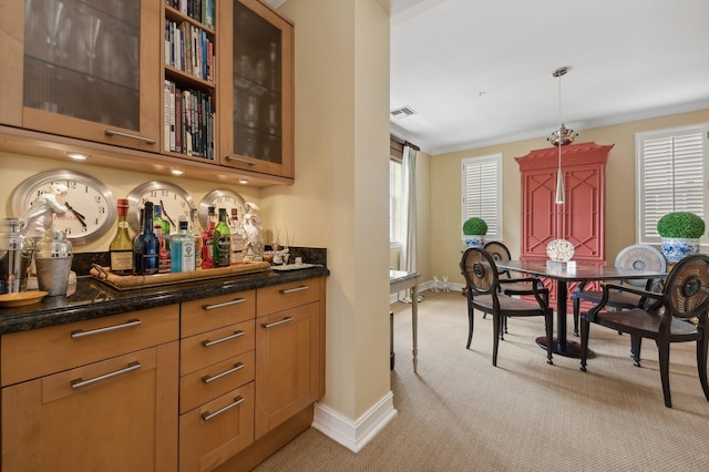 bar with ornamental molding, dark stone countertops, light colored carpet, and pendant lighting