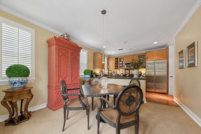 dining space featuring a healthy amount of sunlight, sink, and ornamental molding