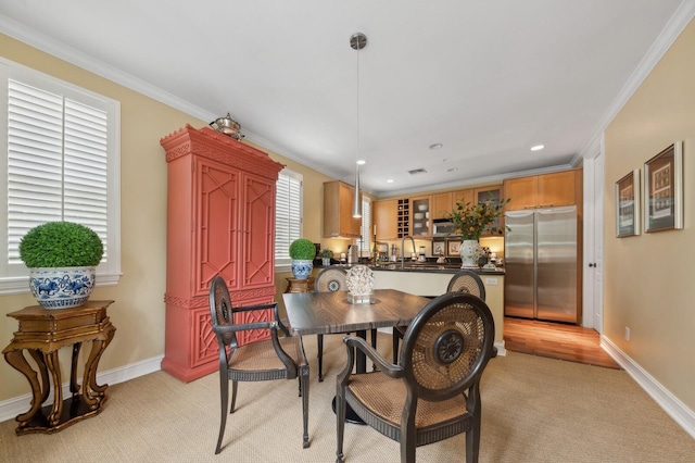 carpeted dining space featuring crown molding and sink