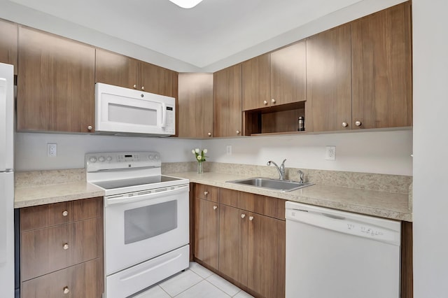 kitchen with light tile patterned flooring, white appliances, and sink