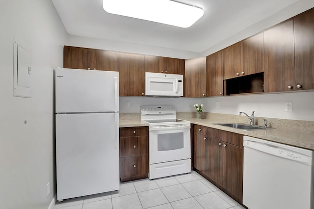 kitchen with sink, dark brown cabinets, light tile patterned floors, and white appliances