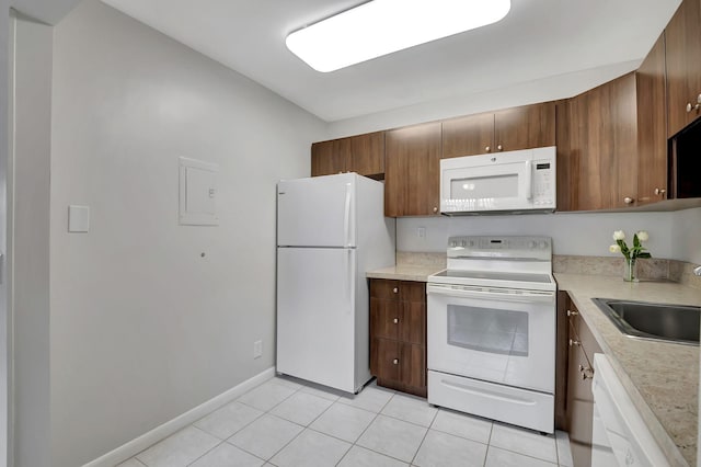 kitchen with light tile patterned flooring, sink, and white appliances