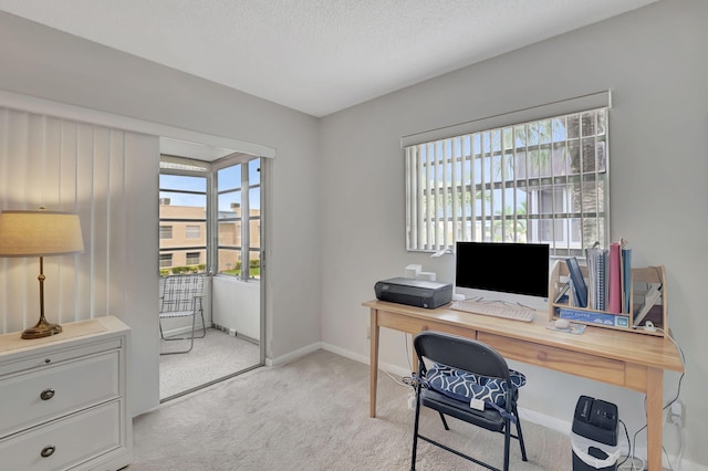 office with a textured ceiling and light colored carpet