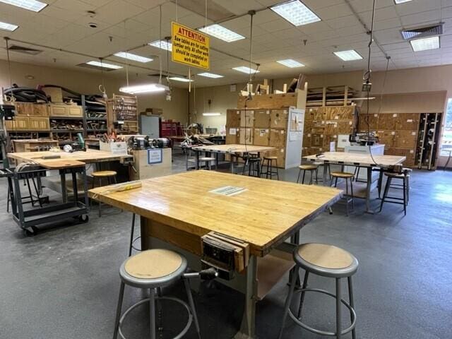 dining space with a workshop area and a drop ceiling