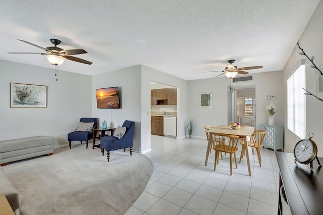 tiled dining space featuring a textured ceiling, sink, and ceiling fan