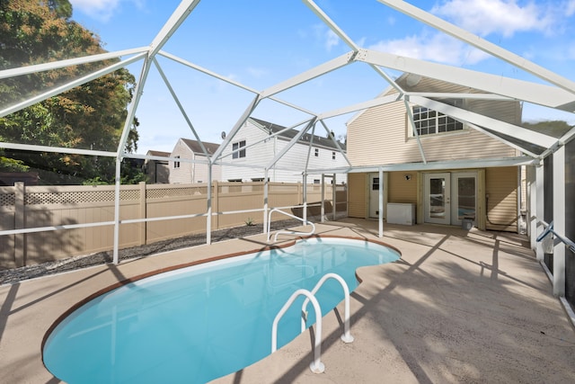 view of pool featuring french doors, glass enclosure, and a patio area