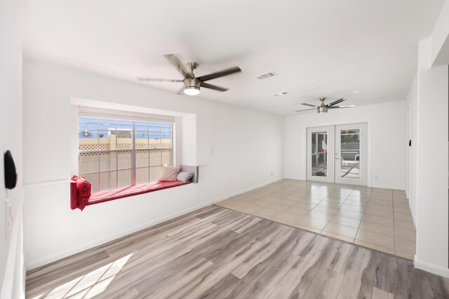 unfurnished room featuring french doors, ceiling fan, and light hardwood / wood-style floors